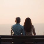 Coppia che guarda l'orizzonte mantenendo spazio personale, simbolo di amore e libertà personale